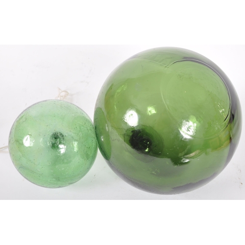 206 - Two early to mid 20th Century pressed green glass witches balls. Largest measures approx; 13cm diame... 