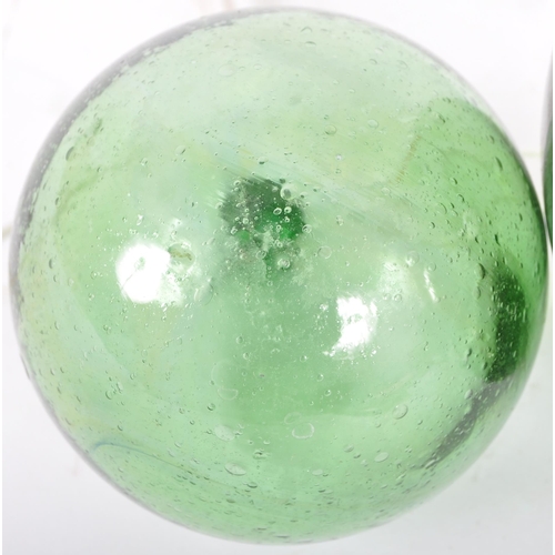 206 - Two early to mid 20th Century pressed green glass witches balls. Largest measures approx; 13cm diame... 