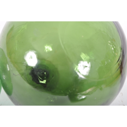 206 - Two early to mid 20th Century pressed green glass witches balls. Largest measures approx; 13cm diame... 