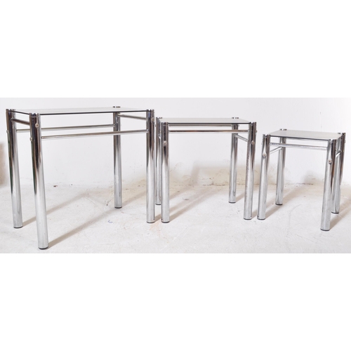 218 - A retro 20th Century 1970s chrome and smoked glass nest of tables. Each nesting table having thick c... 