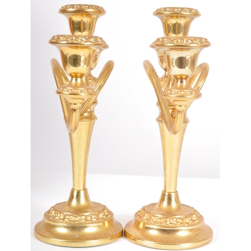 237 - A matching pair of late 20th Century Hollywood Regency gilt candlesticks with each having a central ... 