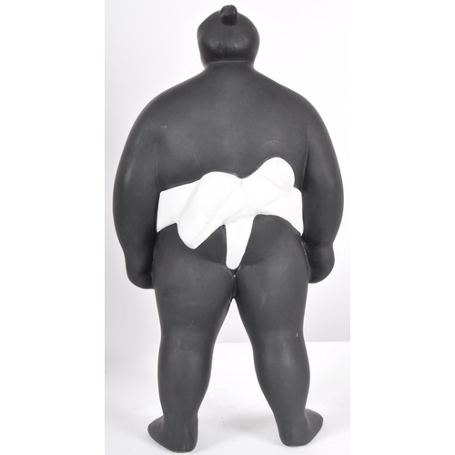 248 - A contemporary ceramic sculpture / figure in the form of a Sumo Wrestler finished in matte black and... 