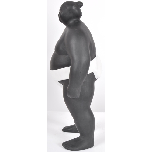 248 - A contemporary ceramic sculpture / figure in the form of a Sumo Wrestler finished in matte black and... 