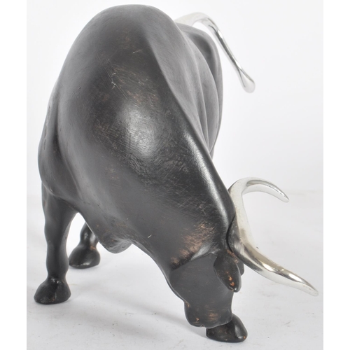 252 - A Contemporary cast resin figure / ornament in the form of a bull finished in black with silver tone... 