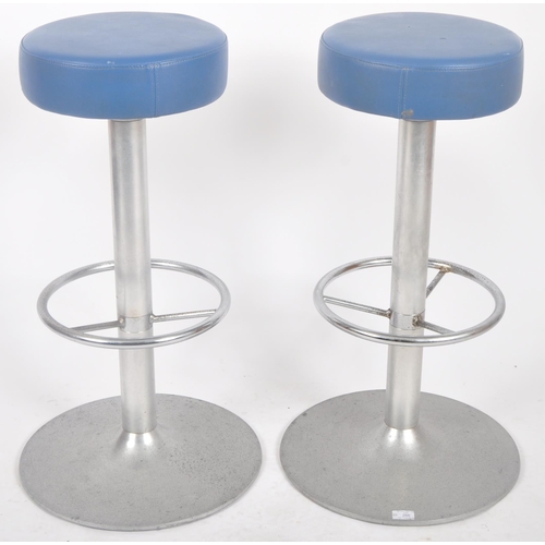 266 - A matching pair of late 20th Century bar stools with each having padded circular seat rests with blu... 