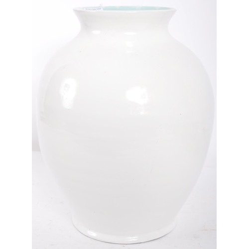 293 - C H Brannam - A retro 20th Century studio art pottery vase of bulbus ribbed form having a white glaz... 