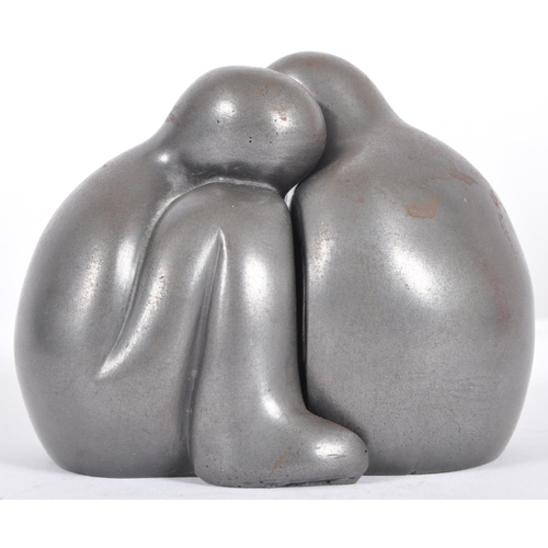 303 - A contemporary two part resin sculpture / figure depicting two figures hugging with a iron paint fin... 