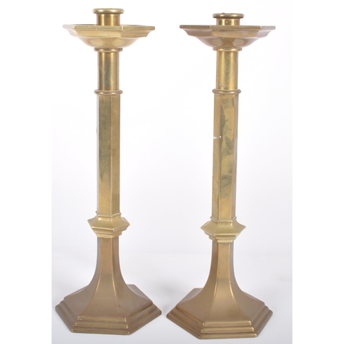 426 - A matching pair of mid 20th Century solid brass candlestick holders of ecclesiastical influence havi... 