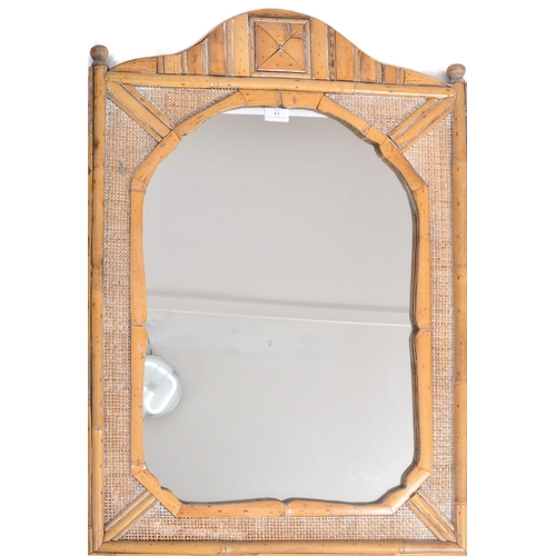 43 - A vintage early 20th Century bamboo and cane wall hanging mirror having a single shaped mirror plate... 