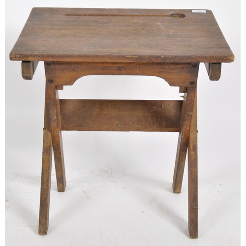 432 - An early 20th Century English school oak folding desk having a indent and inkwell holder to the top ... 