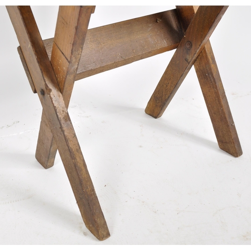 432 - An early 20th Century English school oak folding desk having a indent and inkwell holder to the top ... 