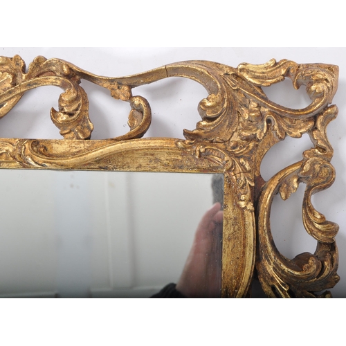 433 - A vintage 20th Century giltwood framed hanging mirror having a foliate and scrolled open frame housi... 