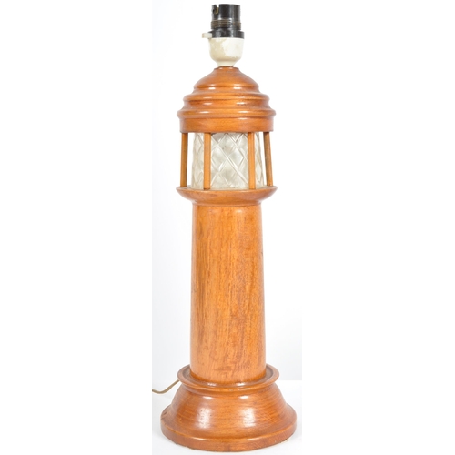 448 - A retro mid 20th Century 1960s teak table lamp light in the form of a lighthouse having an etched fr... 