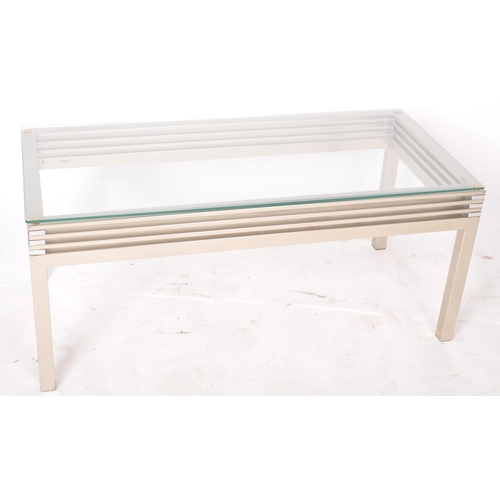 463 - A contemporary designer coffee table / low table of brushed aluminum construction having a thick gla... 