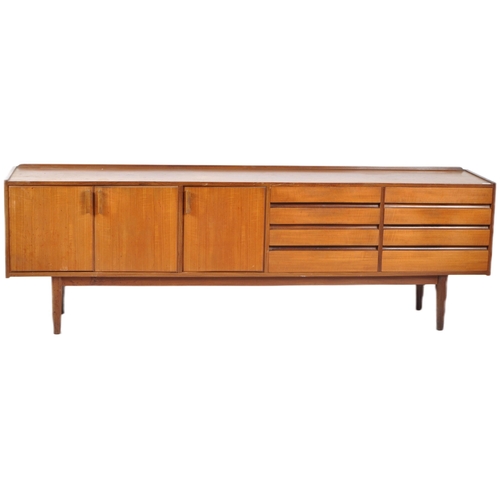 50 - A large mid 20th Century Danish influenced teak wood sideboard credenza having a dual bank of eight ... 