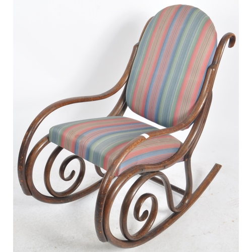 524 - An early 20th Century bentwood rocking chair / armchair having a scrolled rocking fame with padded b... 