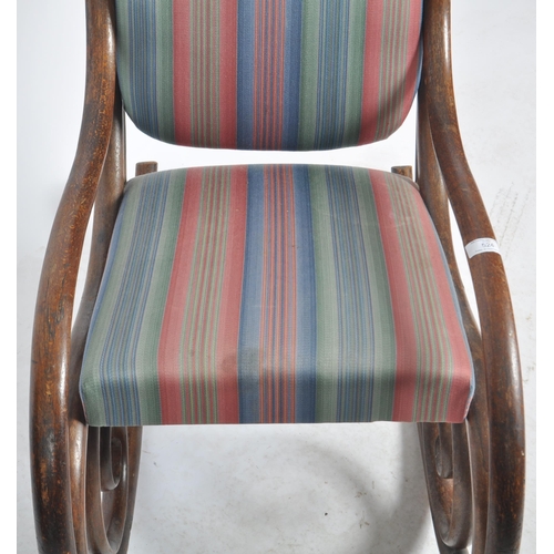 524 - An early 20th Century bentwood rocking chair / armchair having a scrolled rocking fame with padded b... 