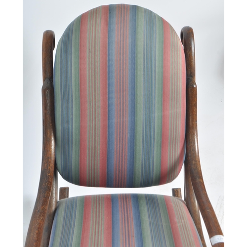 524 - An early 20th Century bentwood rocking chair / armchair having a scrolled rocking fame with padded b... 