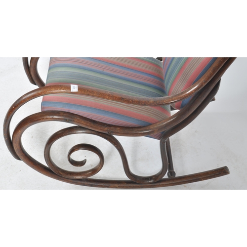 524 - An early 20th Century bentwood rocking chair / armchair having a scrolled rocking fame with padded b... 