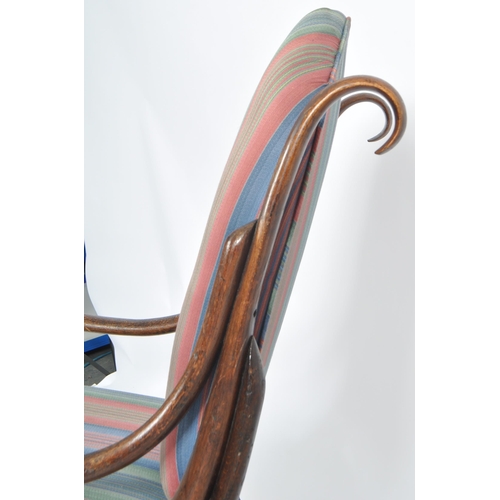 524 - An early 20th Century bentwood rocking chair / armchair having a scrolled rocking fame with padded b... 