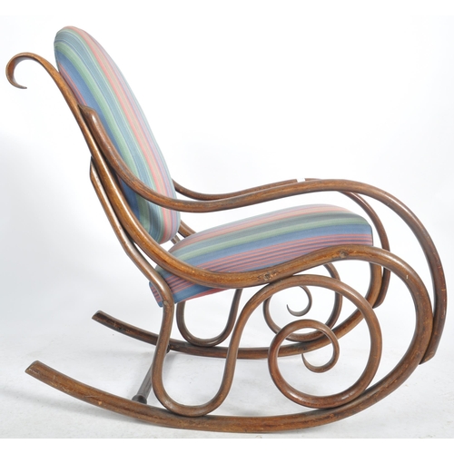 524 - An early 20th Century bentwood rocking chair / armchair having a scrolled rocking fame with padded b... 