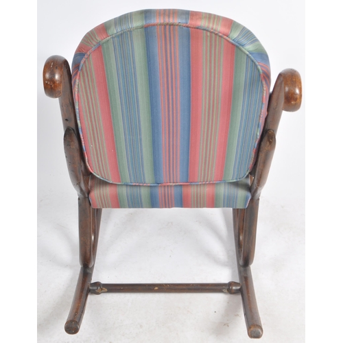 524 - An early 20th Century bentwood rocking chair / armchair having a scrolled rocking fame with padded b... 