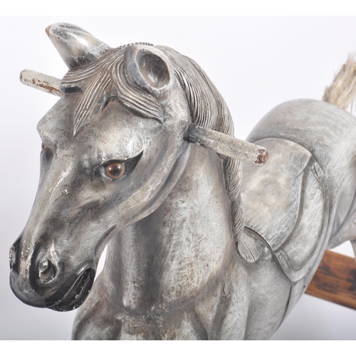 566 - A vintage 20th Century carved wooden rocking horse with detailed carved face a mane with a carved sa... 