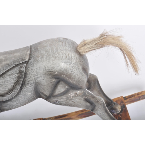 566 - A vintage 20th Century carved wooden rocking horse with detailed carved face a mane with a carved sa... 