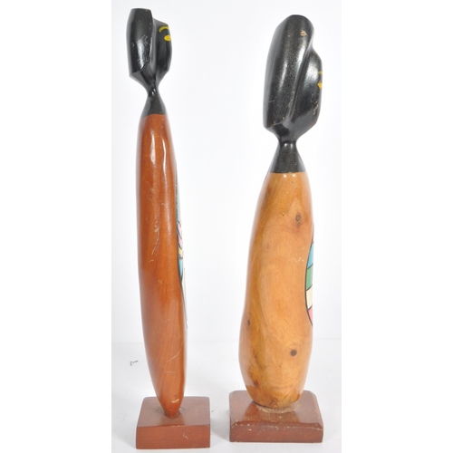 57 - Frank Coronado - A pair of mid Century carved teak stylized figures each with two tone faces and abs... 