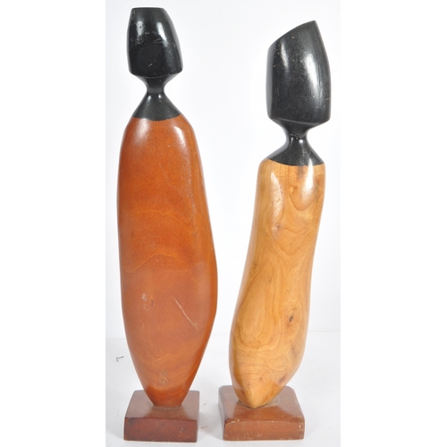 57 - Frank Coronado - A pair of mid Century carved teak stylized figures each with two tone faces and abs... 