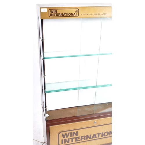 588 - A late 20th Century Win International advertising glass shop display cabinet with twin glazed doors ... 