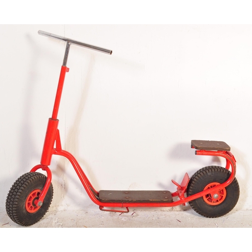 589 - A vintage 20th Century children's scooter finished in red with wooden plinth standing borders and st... 