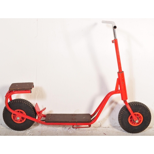 589 - A vintage 20th Century children's scooter finished in red with wooden plinth standing borders and st... 