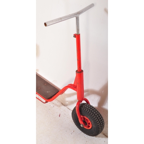 589 - A vintage 20th Century children's scooter finished in red with wooden plinth standing borders and st... 