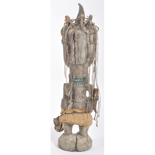 593 - A large 20th Century tribal African figure with horn set to head with inset shells to eyes. Glass be... 