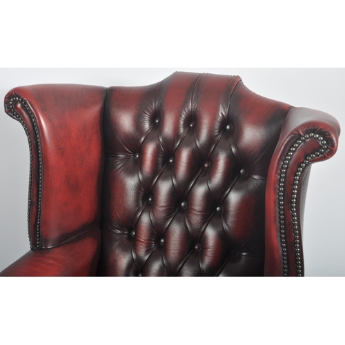 596 - A Queen Anne revival oxblood red leather oxblood Chesterfield wingback armchair raised on cabriole l... 