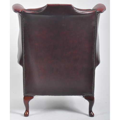 596 - A Queen Anne revival oxblood red leather oxblood Chesterfield wingback armchair raised on cabriole l... 