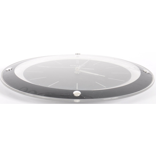 597 - Seiko - A retro late 20th Century clear and black plastic wall clock having baton numerals to the ce... 