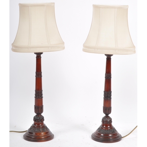 84 - Rochamp Ltd - A matching pair of contemporary carved mahogany table lamp lights having carved stems ... 