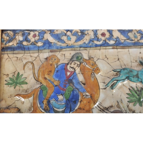 139 - An Iznik Persian Middle Eastern pottery tile. Depicts a man on horse with monkey and other creatures... 