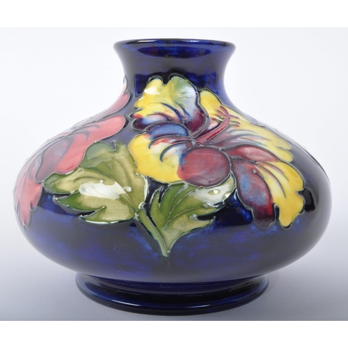 177 - A vintage 20th Century Moorcroft hibiscus squat vase. Having a circular flared top bulbous body with... 