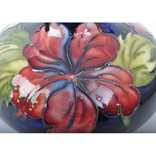 177 - A vintage 20th Century Moorcroft hibiscus squat vase. Having a circular flared top bulbous body with... 