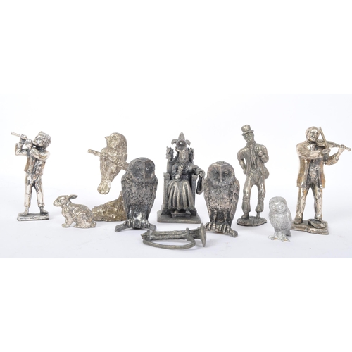 235 - An assortment of cast metal spelter figures to include King Arthur, owls, rabbits, a Dickensian gent... 