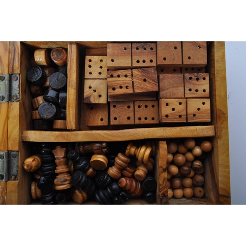 252 - A 20th century burr walnut games compendium. The games box to include draughts, chess, solitaire & d... 