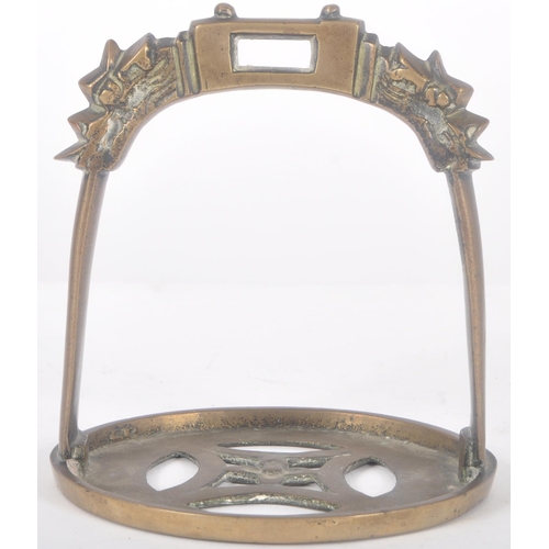 260 - An early 20th Century Chinese Oriental bronze horse stirrup. Ornate arched top with dragon heads lea... 