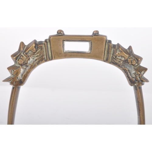 260 - An early 20th Century Chinese Oriental bronze horse stirrup. Ornate arched top with dragon heads lea... 