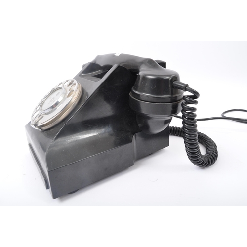 262 - A vintage 20th Century Art Deco bakelite ring dial telephone of typical form finished in black. The ... 