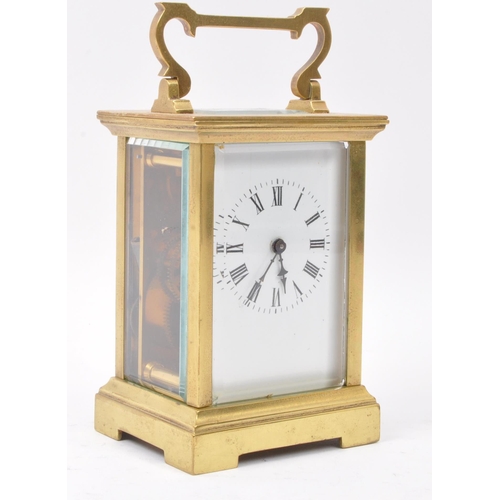 300 - A 20th century brass cased carriage clock with white dial and brass movement, brass handle above esc... 