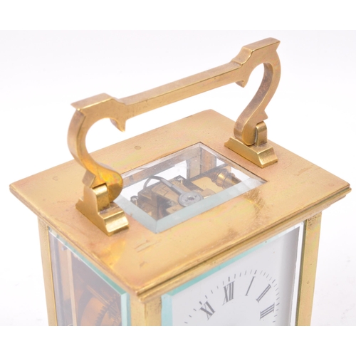 300 - A 20th century brass cased carriage clock with white dial and brass movement, brass handle above esc... 