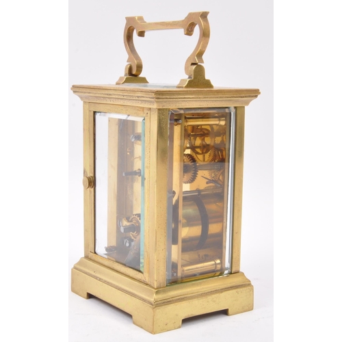 300 - A 20th century brass cased carriage clock with white dial and brass movement, brass handle above esc... 